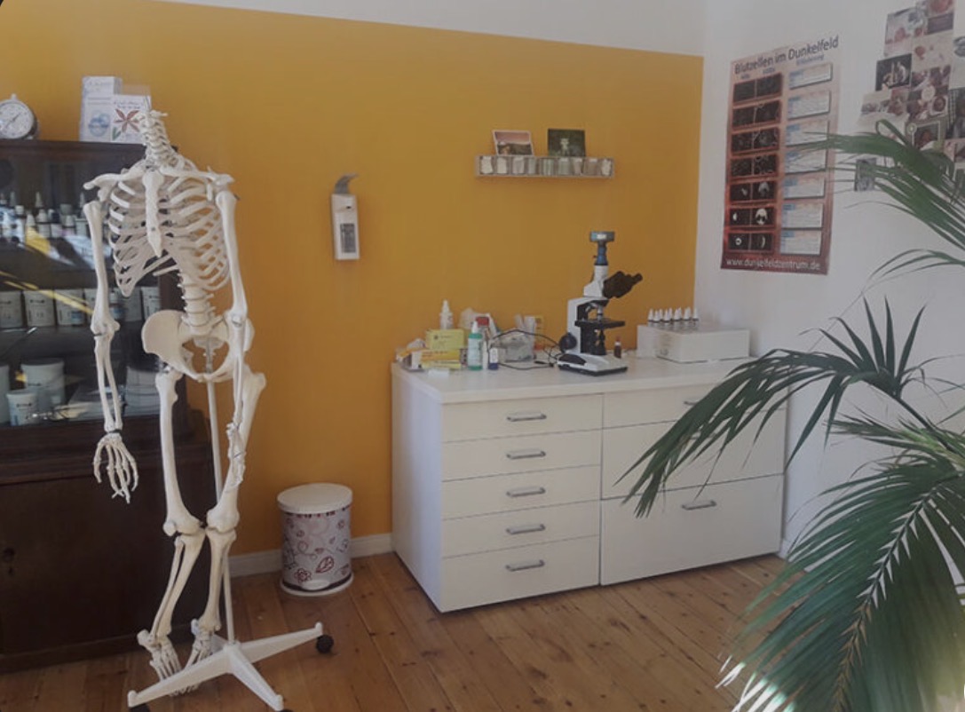 Erste Praxis von Lisa Winnen mit Skelett, Mikroskop und orangefarbener Wand