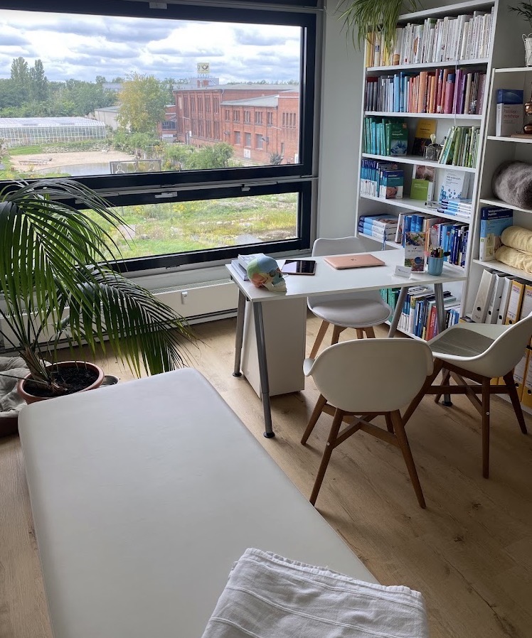 Zweite Praxis von Lisa Winnen mit tiefem Fenster, Behandlungsliege und Fachbibliothek